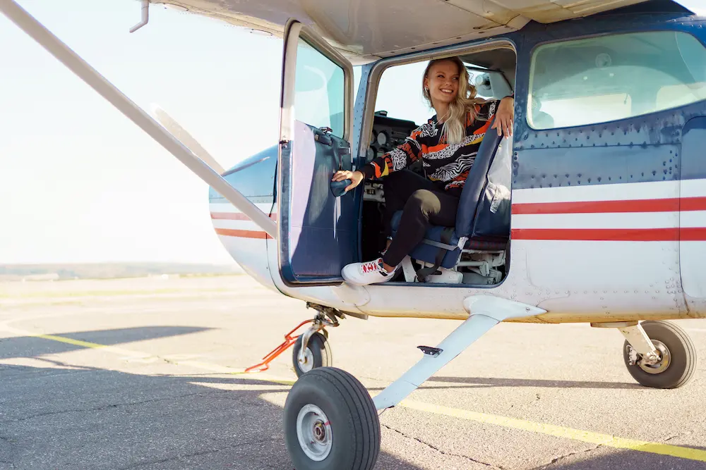 Smiling pilot exiting small plane.