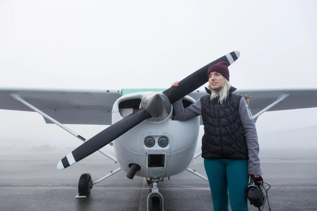 Canadian student pilot beside a Cessna-style training aircraft preparing for a private pilot licence flight lesson.