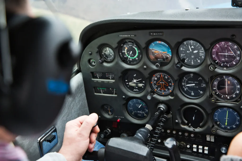 Pilot monitoring basic flight instruments in a light aircraft cockpit during VFR flight.